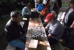 Igor (vorne links) spielt seelenruhig Schach, während seine Frau (rechts) geduldig wartet.